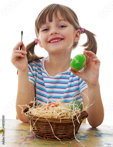Photo: a happy little girl painting easter eggs a happy little girl painting easter eggs