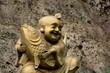 Golden, laughing Buddhist monk with fish of good fortune