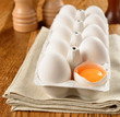 Eggs in the package on a brown table