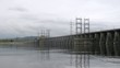 Cars go on bridge in afternoon which is also spillway dike