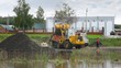 Loader loads coal on dump truck near water