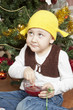 Funny boy eating jam sitting under the christmas tree