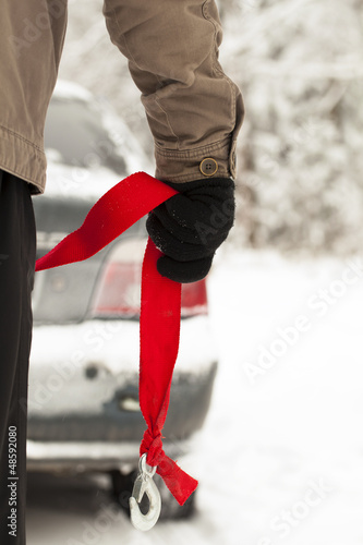 Photo: Man with towing rope hooks near towed car Man with towing rope hooks near towed car