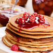 Delicious pancakes with raspberries on the wooden kitchen  table