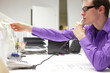 young business man on phone reading note in office