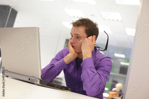 Photo: busy man solving problem in office environment busy man solving problem in office environment