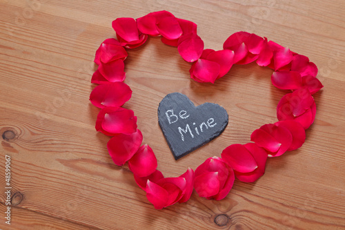 Photo: Romantic love message on slate in a rose petal heart Romantic love message on slate in a rose petal heart