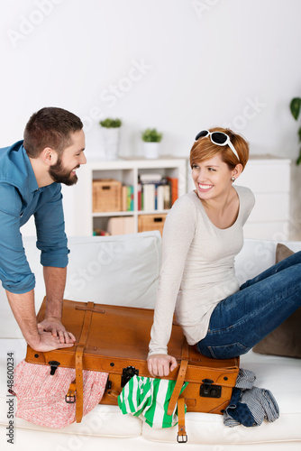 Photo: lachendes paar packt reisekoffer lachendes paar packt reisekoffer