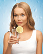 woman with lemon slice on glass of water