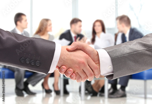 Photo: Closeup of business people shaking hands over a deal Closeup of business people shaking hands over a deal