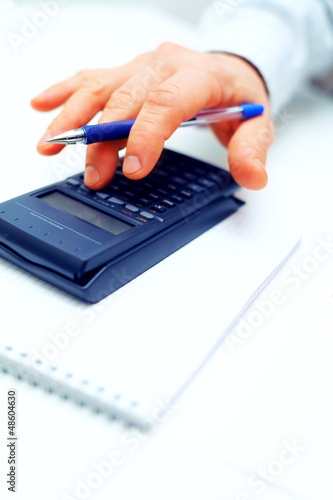 Photo: Closeup of a businessman calculating Closeup of a businessman calculating