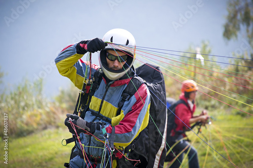 Photo: pilota di parapendio si prepara al decollo pilota di parapendio si prepara al decollo