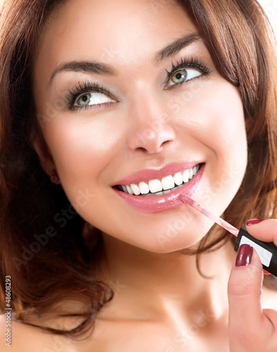 Photo: Beauty Girl Applying Lipgloss. Makeup. Beautiful Woman's Face Beauty Girl Applying Lipgloss. Makeup. Beautiful Woman's Face