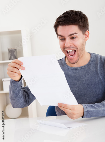 Photo: Exultant young man cheering good news Exultant young man cheering good news