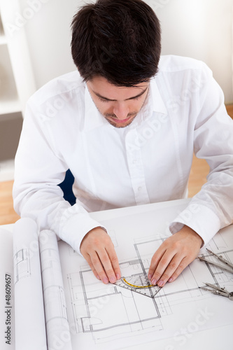 Photo: Architect working on blueprints Architect working on blueprints