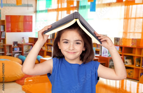 Photo: Brunette little girl with a book on her head Brunette little girl with a book on her head