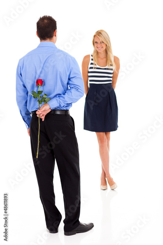 Photo: romantic young man hiding rose behind his back romantic young man hiding rose behind his back