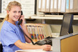 Nurse Making Phone Call At Nurses Station