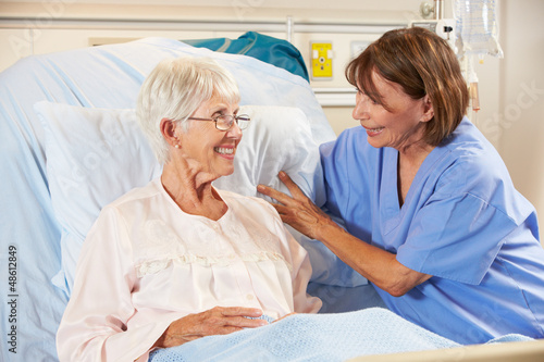 Photo: Nurse Talking To Senior Female Patient In Hospital Bed Nurse Talking To Senior Female Patient In Hospital Bed