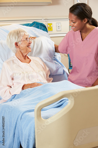 Photo: Nurse Talking To Senior Female Patient In Hospital Bed Nurse Talking To Senior Female Patient In Hospital Bed