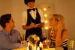 young couple place dinner order to waitress in a restaurant