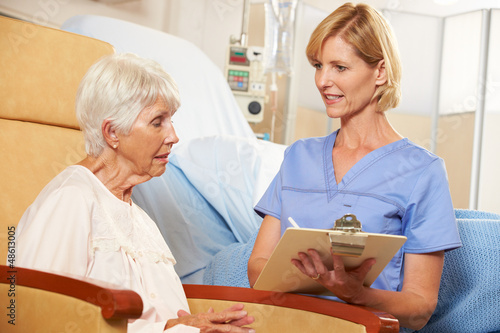 Photo: Nurse Taking Notes From Senior Female Patient Seated In Chair Nurse Taking Notes From Senior Female Patient Seated In Chair