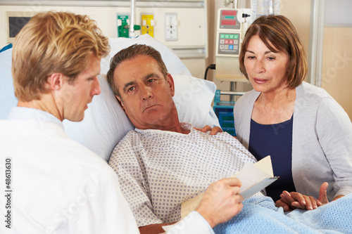 Photo: Doctor Talking To Couple On Ward Doctor Talking To Couple On Ward