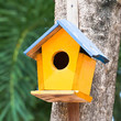 yellow birdhouse on a tree