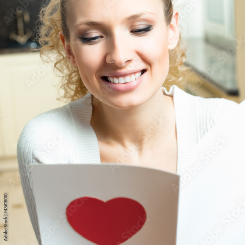 Photo: Cheerful smiling woman, reading valentine card Cheerful smiling woman, reading valentine card