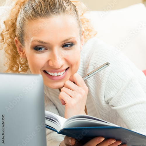 Photo: Cheerful woman working with organizer and laptop Cheerful woman working with organizer and laptop