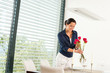 Smiling woman putting red roses dinner room