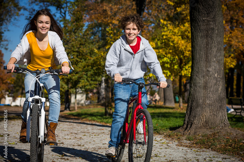 Photo: Urban biking - teens riding bikes in city Urban biking - teens riding bikes in city