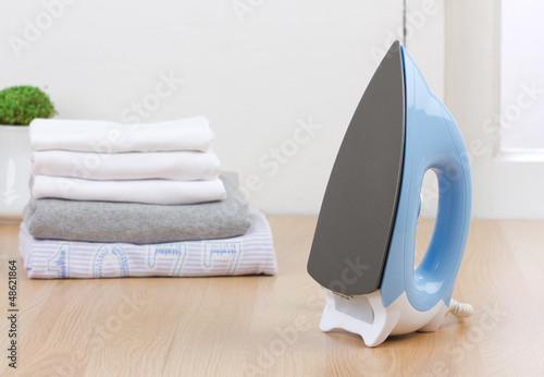 Photo: The electric iron with stacks of cloths The electric iron with stacks of cloths