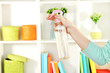 Sprayed air freshener in hand on white shelves background