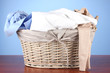 Bright clothes in laundry basket,on color background