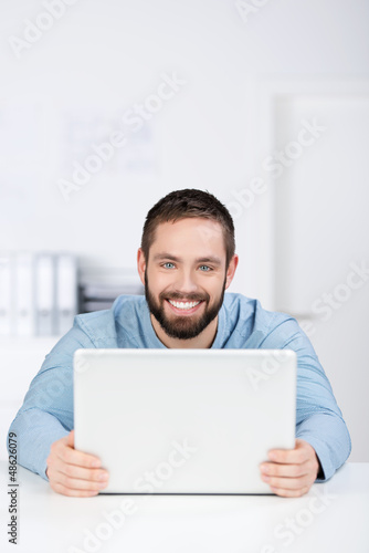Photo: mann mit laptop im büro mann mit laptop im büro