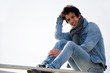 Jeune assis en hauteur  tout en jeans