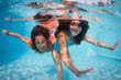 Photo: Mother and daughter having fun underwater in swimming pool. Mother and daughter having fun underwater in swimming pool.