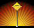 Under construction road sign on rays background