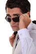 Businessman peering over his sunglasses