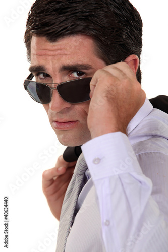 Photo: Businessman peering over his sunglasses Businessman peering over his sunglasses