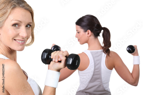 Photo: Two women lifting weights together Two women lifting weights together
