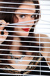 Attractive woman peeking through some blinds