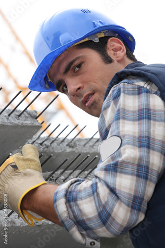 Photo: Construction worker with slabs of reinforced concrete Construction worker with slabs of reinforced concrete