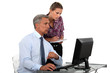 businessman in office with computer and young female assistant