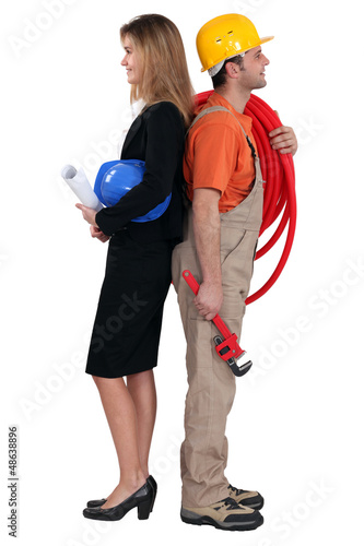 Photo: Engineer and workman standing back to back Engineer and workman standing back to back