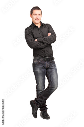 Photo: Full length portrait of a young male leaning against wall Full length portrait of a young male leaning against wall