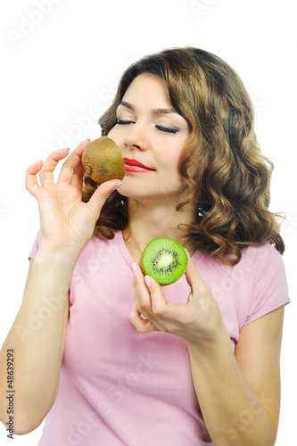 Photo: Beuatiful young girl smelling kiwi isolated on white Beuatiful young girl smelling kiwi isolated on white