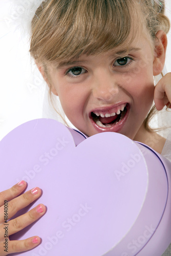Photo: Little girl holding heart-shaped box Little girl holding heart-shaped box