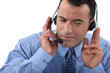 Businessman struggling to hear his headset